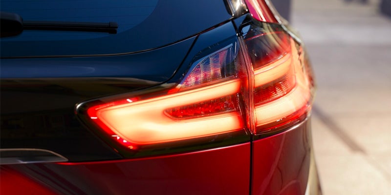: Close-up of a red car's LED tail light illuminated at night