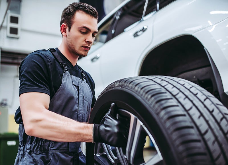 Service Technician Inspecting The Tires